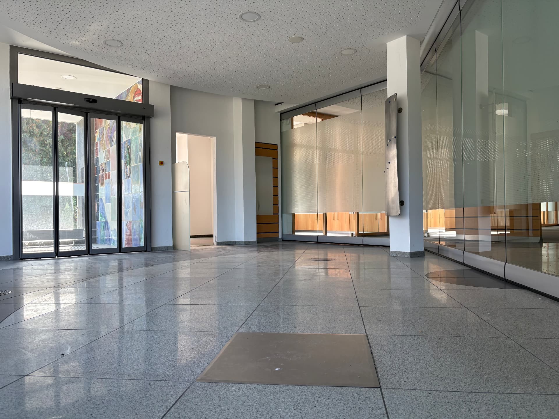 Offener Empfang mit automatischer Schiebetür, Glasfronten und viel Tageslicht
