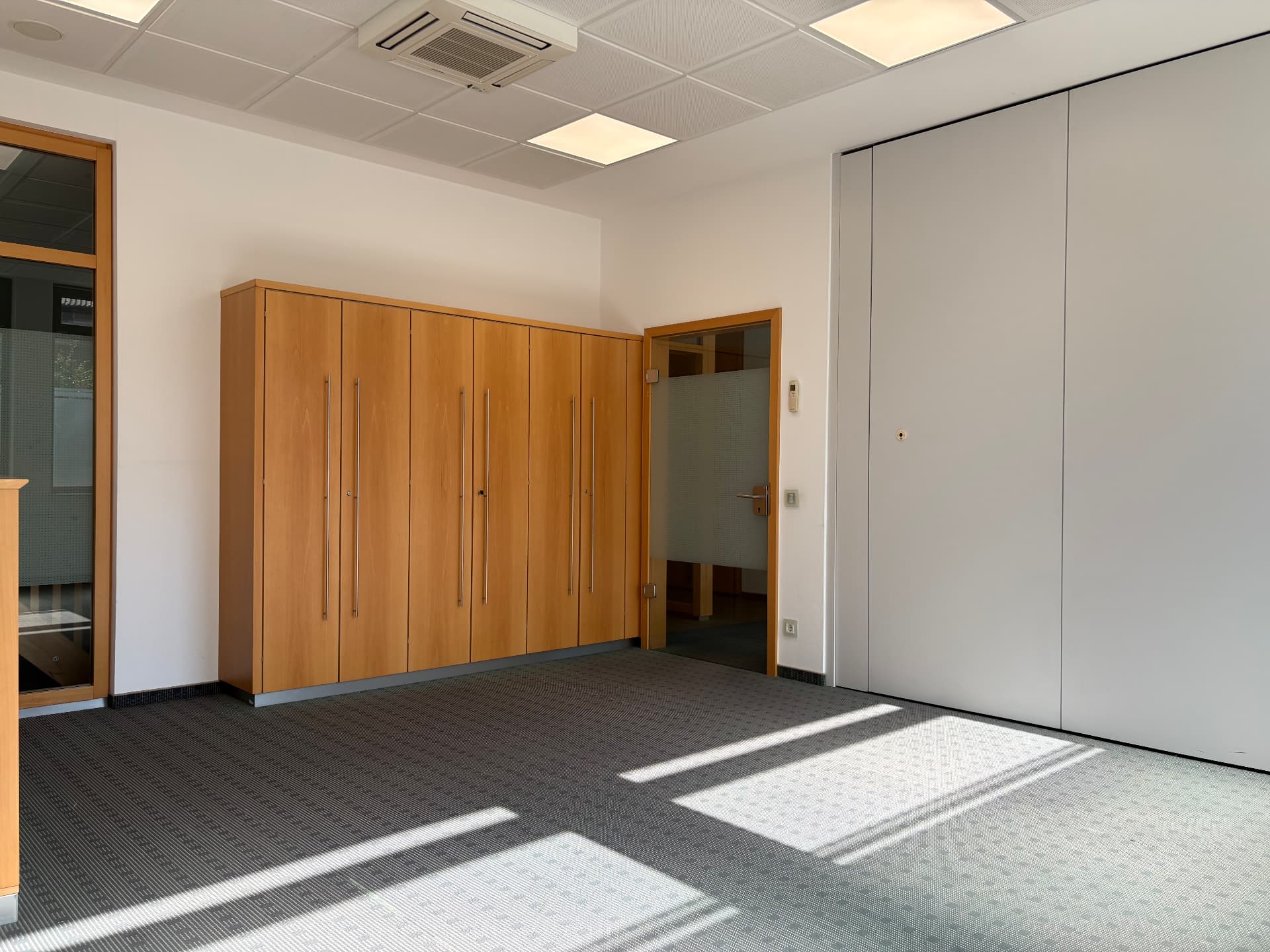 Büroraum mit Einbauschrank, geschlossener Trennwand und Decken-Klimagerät