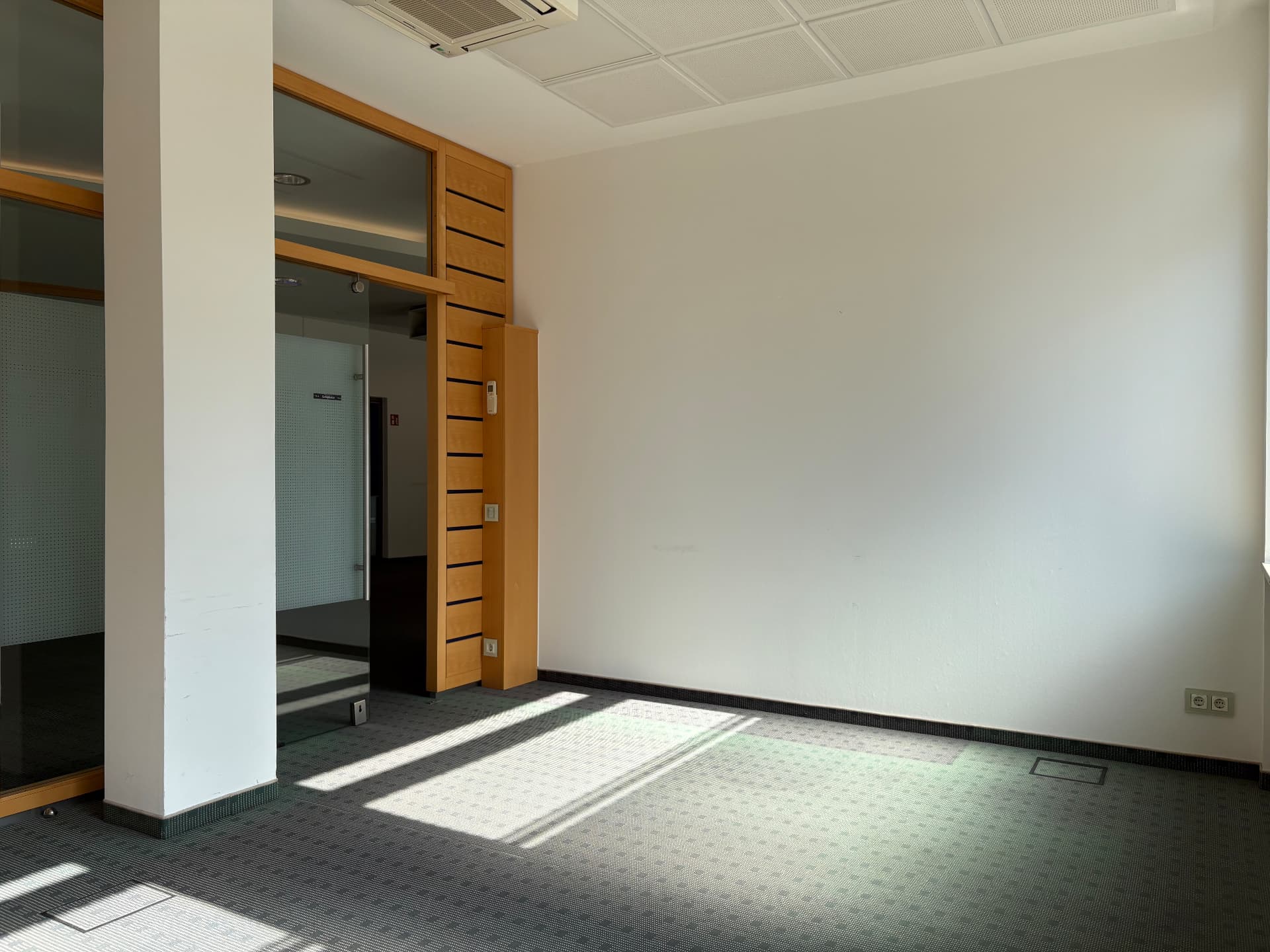 Lichtdurchfluteter Raum mit Glaszugang und Boden- bzw. Wandanschlüssen